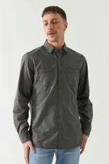 Camisa de gabardina gris con corte slim, mangas largas, cartera abotonada y dos bolsillos con solapa en el pecho.