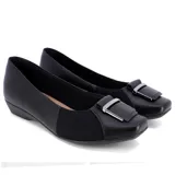 Zapato de vestir Usaflex Viena, color negro, con capellada de cuero y laterales de tejido elástico. Presenta detalle de hebilla plateada en la punta y taco bajo.