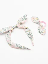 Set de tiara y colero con moña de tela estampada con flores en tonos rosa, verde y blanco.