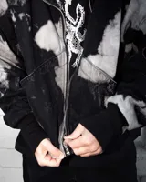 Campera bomber de jean color negro con estampado overo, cuello de cuero, puños de algodón y cierre frontal con cremallera.