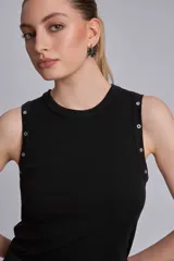 Musculosa marrón de tejido liso, con cuello redondo y tachas metálicas decorativas en los hombros.