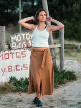 Falda midi marrón con lazo en la cintura, bolsillos laterales y tajo frontal.