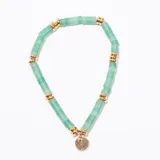 Pulsera elástica compuesta por cuentas cilíndricas de piedra verde jade o aventurina, separadas por espaciadores redondos de metal dorado. Incluye un dije circular plano de metal dorado.