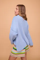 Buzo color crema tejido en algodón, de silueta holgada, mangas anchas y cuello bote.