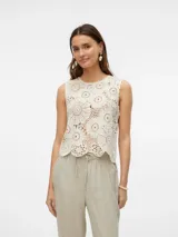 Top sin mangas color blanco roto, tejido a crochet con diseño de círculos concéntricos y bordes festoneados.