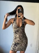 Vestido corto marrón con estampado abstracto, escote halter y espalda descubierta.