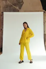 Chaqueta amarilla de lino con bordados en mangas y bolsillos, corte recto y cuello camisero.