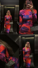 Vestido midi ajustado con estampado abstracto en tonos naranja, rosa y azul. Tiene cuello alto y mangas largas.