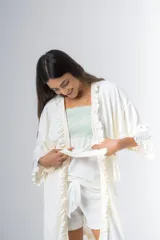 Bata kimono gris claro de algodón con volados en mangas y ruedo. Tiene mangas al codo y lazo de algodón para ajustar en la cintura.