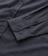 Camisa de manga larga color blanco, confeccionada en tricolina de algodón con efecto melange. Tiene cuello inglés, abotonado delantero y puños con botones.