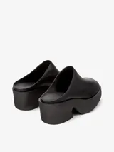 Zueco negro de piel vacuna con plataforma y tacón de 6,8 cm. Cuenta con plantilla reciclada OrthoLite y suela de EVA para mayor ligereza y confort.