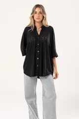 Camisa negra con calados, escote en V, abotonada y manga 3/4.