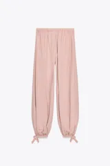 Pantalón bombacho de lyocell color rosa pálido, con cintura elástica y lazos ajustables en los tobillos.