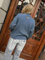 Campera tejida color azul con textura vanizada y cierre frontal.