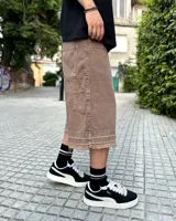 Bermuda de corte baggy color marrón con efecto gastado (lavado vintage), doble carpintero y detalle artesanal visible en el bajo. Incluye un cordón extra confeccionado en la misma tela.