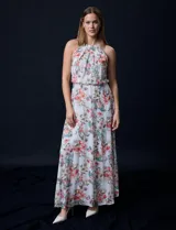 Vestido largo de gasa estampada con flores de colores, escote halter plisado, corte en la cintura elastizado, abertura en la espalda con lazo de ajuste y forro interno a tono.