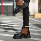 Borcego de cuero vacuno negro, con suela de goma y caña alta de 11 cm.
