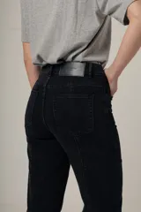 Jean de calce recto y tiro alto, color azul oscuro. Presenta costuras verticales en el frente.