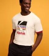 Remera de algodón color crema con cuello redondo y mangas cortas con ribete rojo. Estampa frontal con el logo de Kodak.