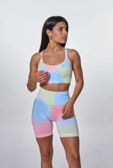 Conjunto deportivo de calza ciclista y top con estampado tie-dye en tonos pastel: rosa, celeste, verde y amarillo. El top es de breteles finos y tiene el logo 'bk.' estampado en el frente.