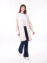 Saco color beige de tejido de punto, con mangas largas y corte holgado.