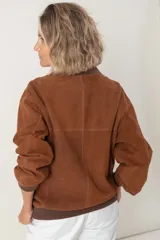 Campera estilo bomber color marrón, unisex, confeccionada en cuero tipo antílope, con cierre frontal y bolsillos laterales.