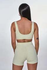 Conjunto deportivo color verde claro, compuesto por un top con breteles anchos y un short ajustado de cintura alta.