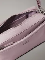Bandolera Calvin Klein modelo Must, color lila, con correa ajustable y logo plateado en el frente. Incluye bolsillo exterior con cierre y bolsillo interior.
