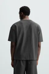 Camiseta de hombre color gris oscuro, de corte amplio, cuello redondo y manga corta.