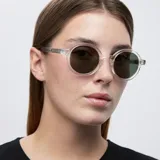 Lentes de sol redondos con montura transparente y lentes verdes polarizadas.