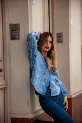 Camisa celeste con estampado de flores blancas, corte clásico, cuello camisero y mangas largas abullonadas.