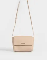 Bandolera color beige de cuerina con solapa, tag metálico y correa larga regulable.