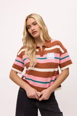 Remera tejida con rayas horizontales marrones, rosas y turquesas, cuello polo y calce boxy.