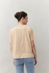 Remera color beige de manga corta con bordado frontal con la frase “L’amour toujours”.