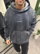 Canguro gris con efecto batik, corte oversize, capucha y bolsillo tipo canguro.