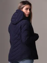 Campera acolchada azul marino con capucha, cierre de cremallera frontal y bolsillos laterales con cremallera. Diseño plegable con logo de Calvin Klein en la manga.