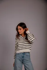 Sweater de punto color beige con rayas horizontales blancas, cuello polo con cierre de cremallera y mangas largas.