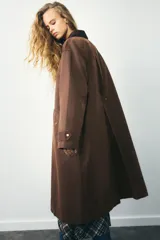 Trench color verde oscuro con cuello solapa combinado en pana marrón y manga larga. Detalle de acabados con trabillas y pinza en espalda. Bolsillos delanteros con solapa y botón a presión. Tejido encerado efecto lavado. Cierre frontal con botones a presión.