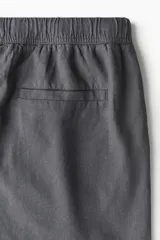 Short gris oscuro de lino y algodón, corte relaxed fit, con cintura elastizada ajustable con cordón, bolsillos laterales y bolsillo trasero.