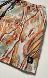 Short de baño con estampado abstracto en tonos verde, naranja y celeste. Tiene cintura elástica con cordón ajustable.