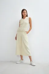 Chaleco tejido color beige con escote en V y diseño de punto trenzado.