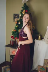 Vestido largo color marrón cobrizo con escote en V, cut outs laterales bajo el busto y breteles finos que se cruzan y atan en la espalda. Presenta un top con estampado abstracto en tonos marrones y dorados.