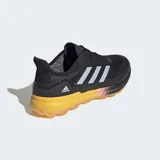 Championes deportivos Adidas Adipower Field Hockey 2.1, color negro con tres franjas plateadas en el lateral. Posee una entresuela gruesa de color amarillo mostaza y suela de goma color caramelo con tacos multidireccionales.
