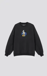Buzo negro de frisa con calce oversize y estampa de Mickey Mouse vestido de chef sobre un círculo azul.
