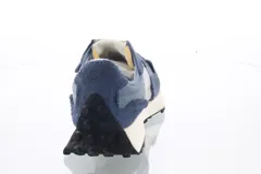 Championes urbanos New Balance, color azul con detalles en gris y blanco, confeccionados en gamuza y tela, con logo "N" característico en los laterales y suela de goma.