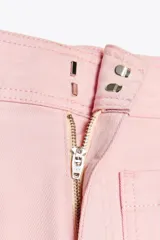 Pantalón de jean color rosa, de tiro alto, corte recto y largo hasta el tobillo. Presenta bolsillos de parche delanteros y traseros, trabillas en la cintura y cierre frontal con cremallera y botón.