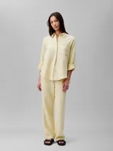 Pantalón de gasa doble color amarillo pálido, de corte recto y cintura elástica con cordones.