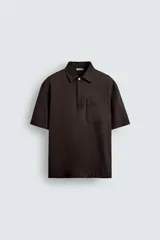 Camisa tipo polo de corte relajado confeccionada en una mezcla de lyocell y algodón. Presenta cuello con solapa, cierre frontal de botones ocultos, manga corta y un bolsillo de parche en el pecho. El bajo cuenta con aberturas laterales.