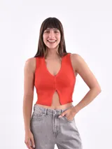 Musculosa tejida de punto acanalado color rojo, con escote en V y cierre frontal con botones.