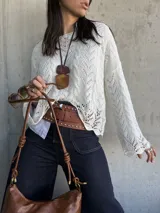 Sweater de hilo color natural con mangas acampanadas y calado en el tejido.
